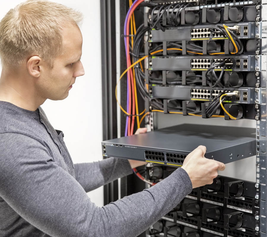 IES electrician working on the data cabling in a server rack.