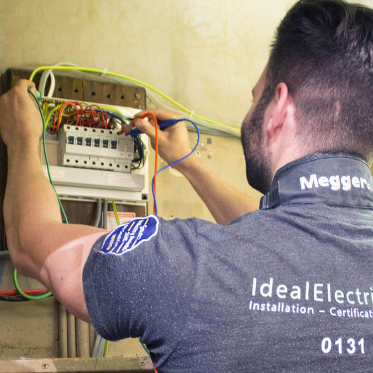 IES electrician testing a fuse board (consumer unit) during an EICR test.