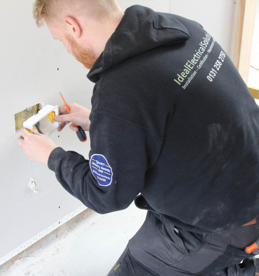 Electrician fitting new plug points during a rewire at an Airbnb short-term let.