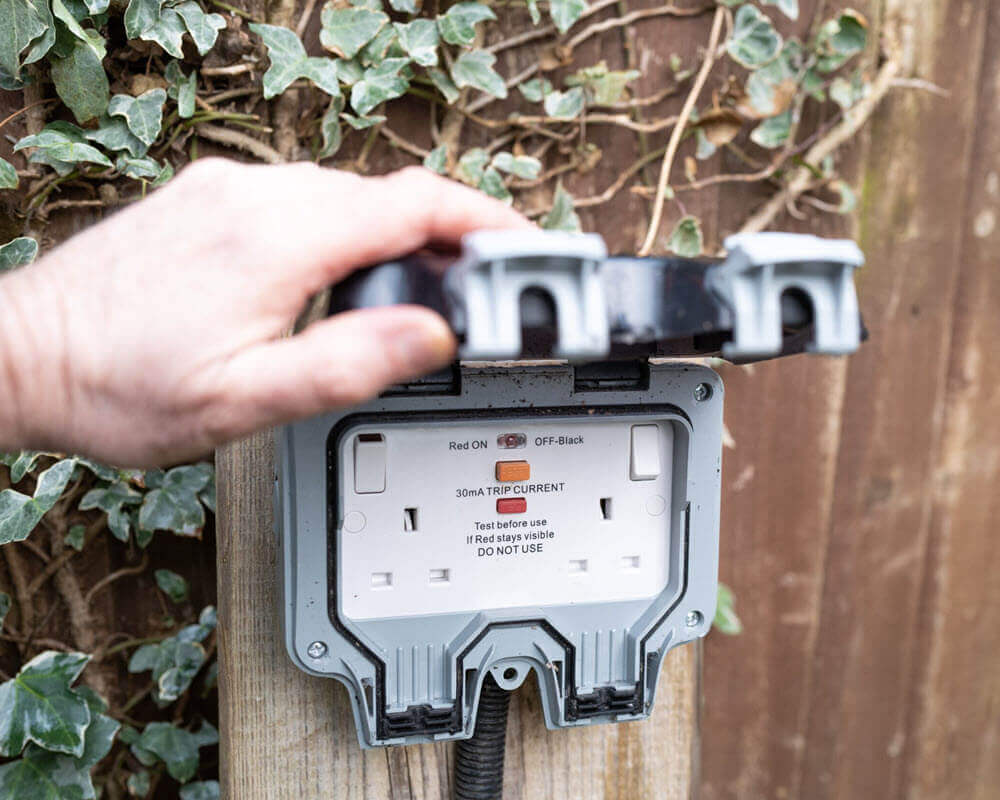 IP rated exterior power socket installed in garden.
