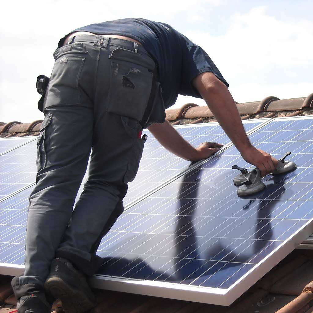 Installing a small plug-in solar setup on a roof terrace.